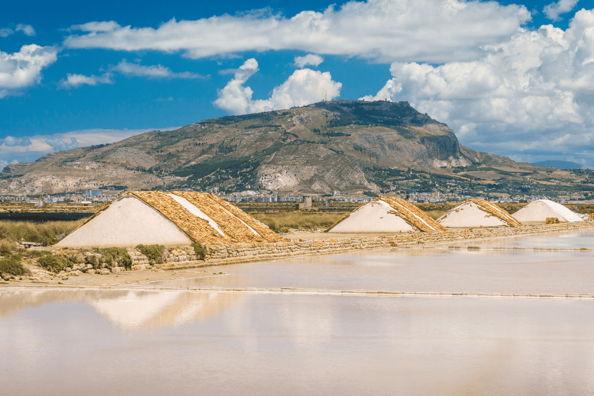 Vista spettacolare sui cumuli di sale con il paesaggio montuoso di Trapani sullo sfondo