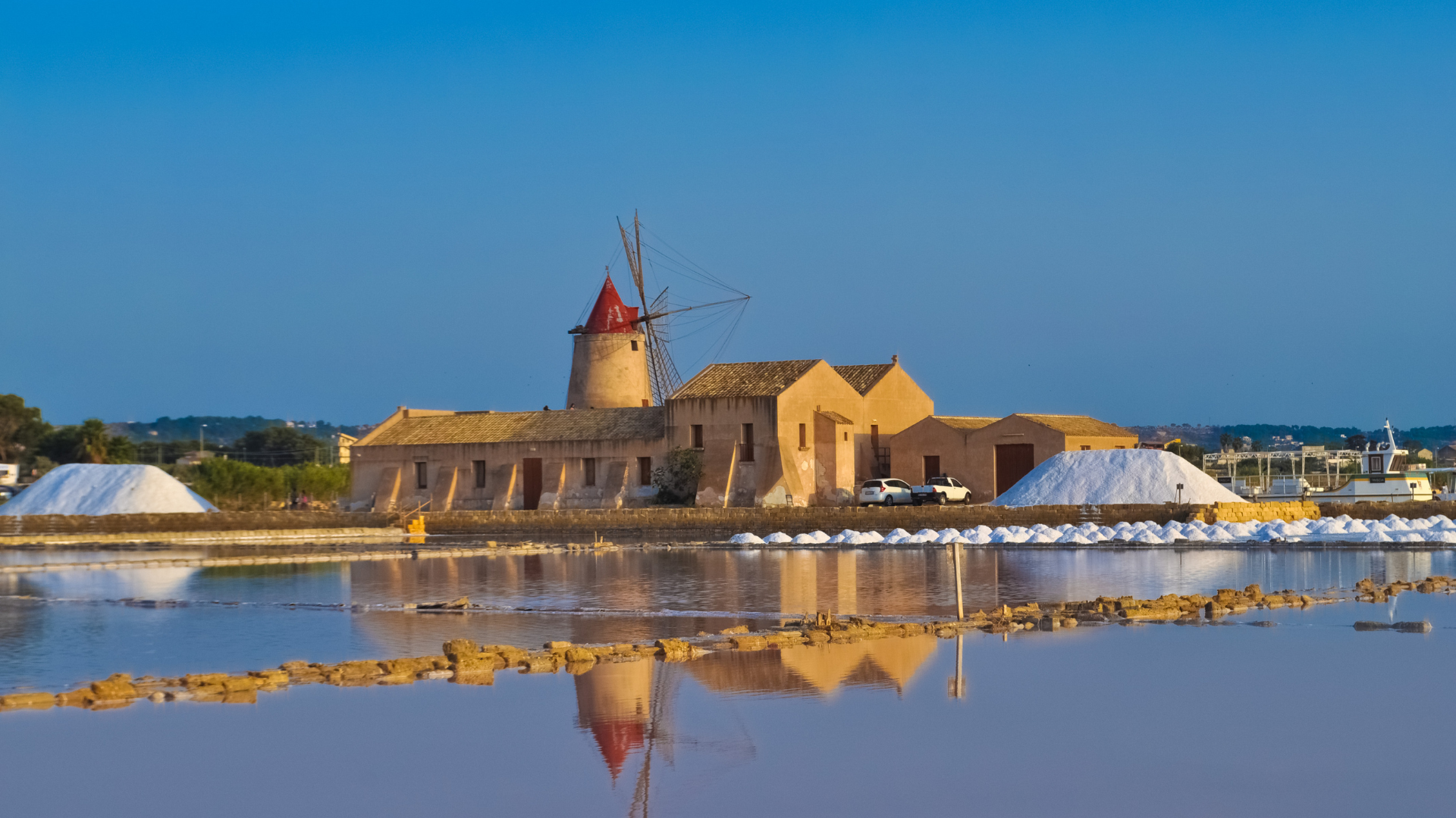 Veduta delle saline di Marsala con mulini a vento al tramonto